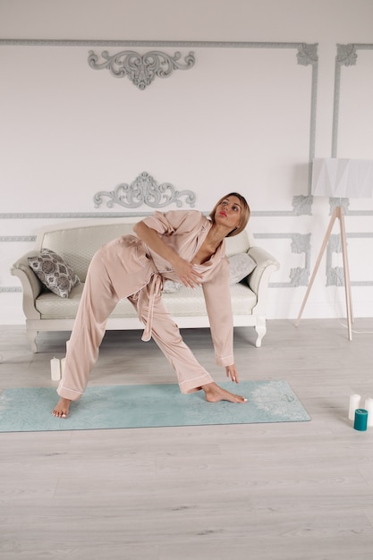 Joven hermosa mujer caucásica con cabello rubio y cara bonita haciendo yoga en diferentes poses