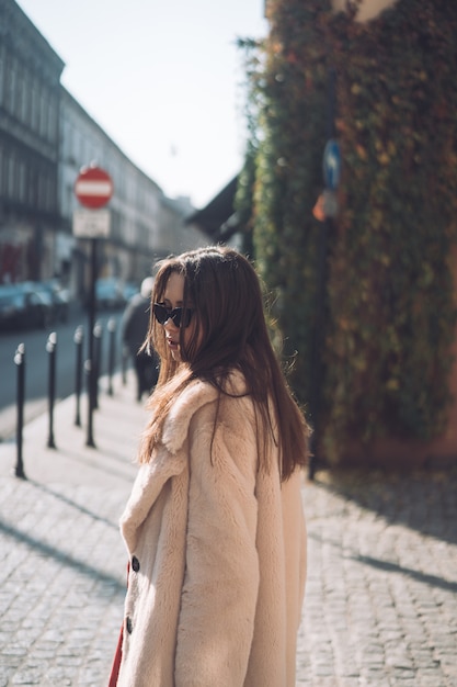 Foto gratuita joven hermosa mujer elegante caminando en abrigo rosa