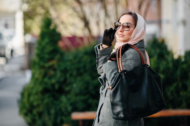 Joven hermosa mujer feliz en un abrigo posando en el parque