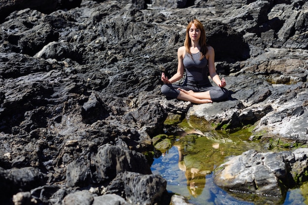 Foto gratuita joven hermosa mujer haciendo yoga en la naturaleza