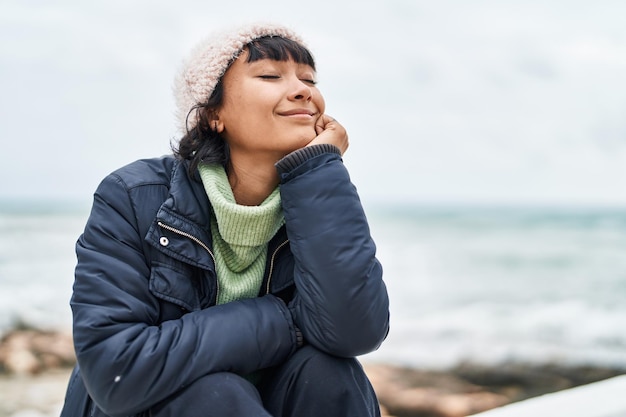 Foto gratuita joven hermosa mujer hispana respirando en la playa