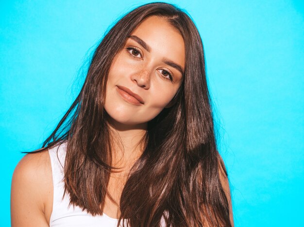 Joven hermosa mujer mirando. Chica de moda en ropa casual de verano. Mujer divertida y positiva posando junto a la pared azul