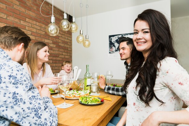 Joven hermosa mujer sentada con amigos