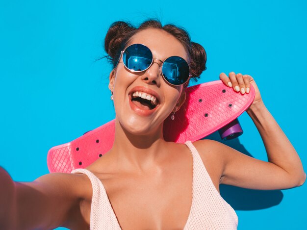 Joven hermosa mujer sexy hipster sonriente en gafas de sol.