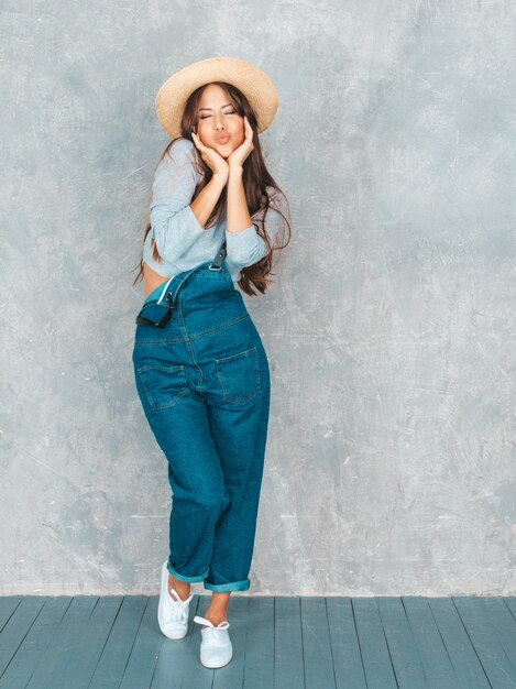 Joven hermosa mujer sonriente mirando. Chica de moda en ropa casual de verano y sombrero ... Hacer cara de pato