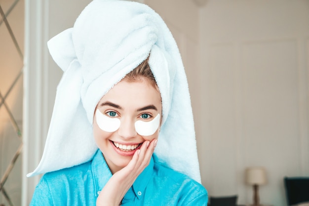 Foto gratuita joven hermosa mujer sonriente con parches debajo de los ojos