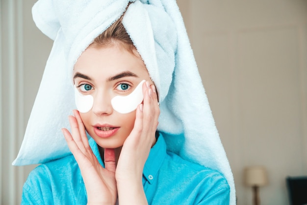 Foto gratuita joven hermosa mujer sonriente con parches debajo de los ojos