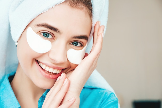 Joven hermosa mujer sonriente con parches debajo de los ojos