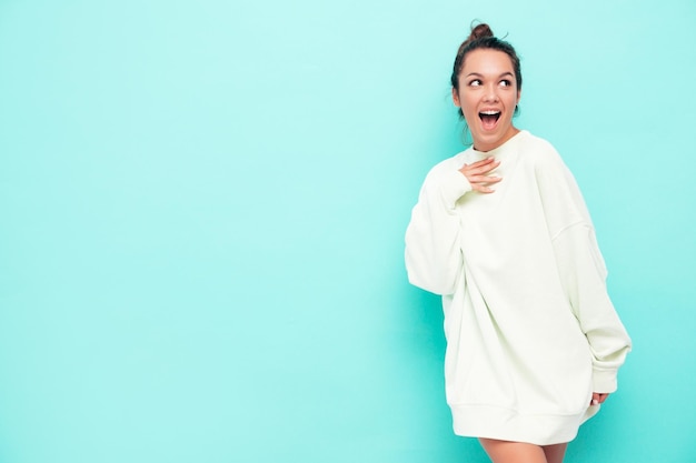 Foto gratuita joven hermosa mujer sonriente en ropa de verano de moda mujer despreocupada posando cerca de la pared en el estudio modelo morena positiva divirtiéndose alegre y feliz conmocionado y sorprendido