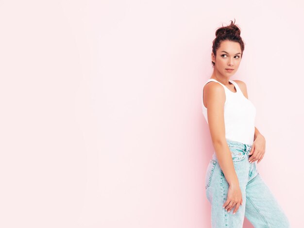 Joven hermosa mujer sonriente en ropa de verano de moda mujer despreocupada posando junto a la pared en el estudio Modelo morena positiva divirtiéndose Alegre y feliz