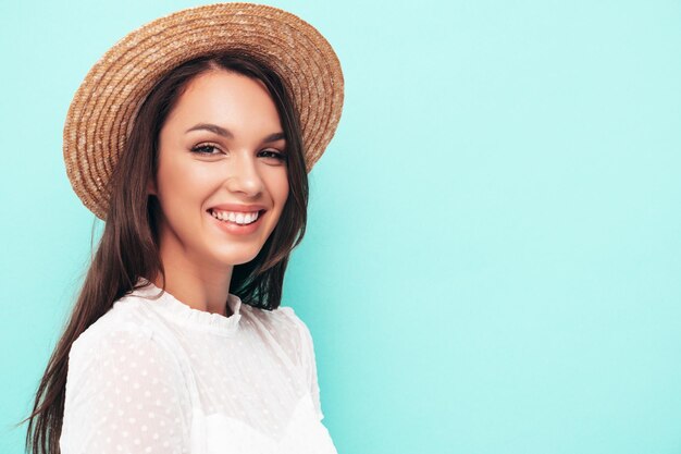 Joven hermosa mujer sonriente en ropa de verano de moda Mujer sexy despreocupada posando junto a la pared en el estudio Modelo morena positiva divirtiéndose Alegre y feliz Con sombrero