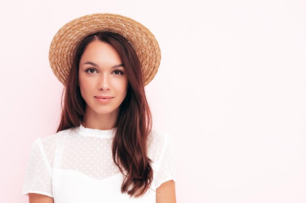 Joven hermosa mujer sonriente en ropa de verano de moda Mujer sexy despreocupada posando junto a la pared rosa en el estudio Modelo morena positiva divirtiéndose Alegre y feliz Con sombrero