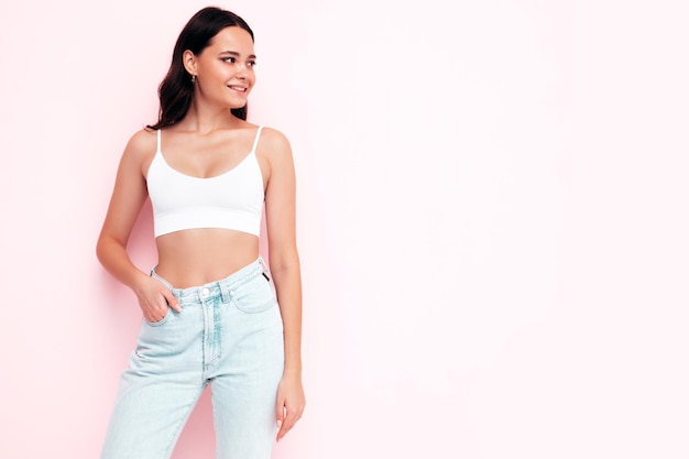 Joven hermosa mujer sonriente en ropa de verano de moda Mujer sexy despreocupada posando junto a la pared rosa en el estudio Modelo morena positiva divirtiéndose y volviéndose loca Alegre y feliz