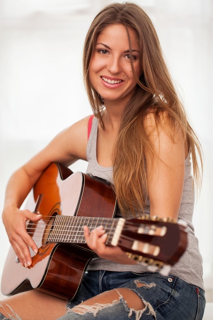 Foto gratuita joven hermosa mujer tocando la guitarra