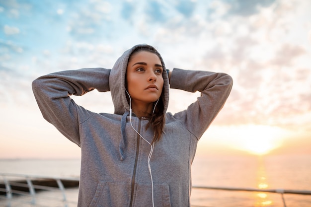 Foto gratuita joven hermosa niña deportiva entrenamiento al amanecer sobre el mar.