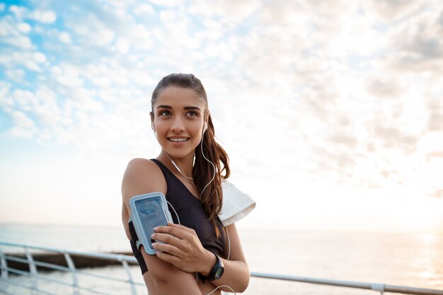 Joven hermosa niña deportiva entrenamiento al amanecer sobre el mar.