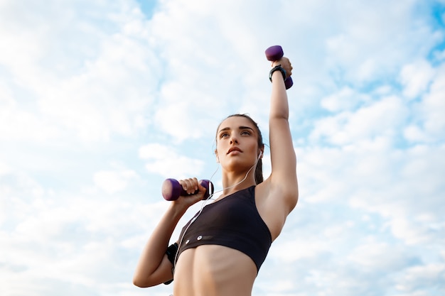 Foto gratuita joven hermosa niña deportiva entrenamiento al amanecer sobre el mar.