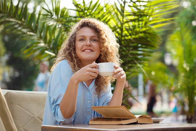 Foto gratuita joven hermosa niña sentada en la cafetería.