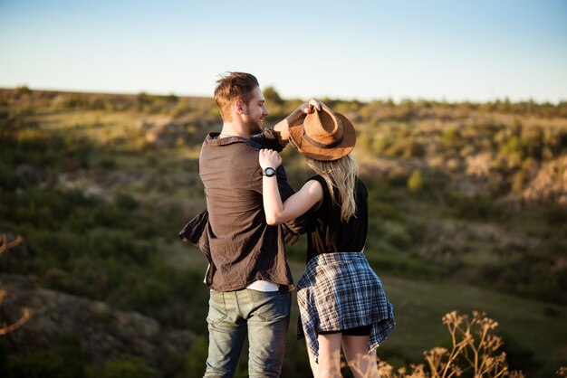 Joven hermosa pareja descansando, disfrutando de la vista en el cañón