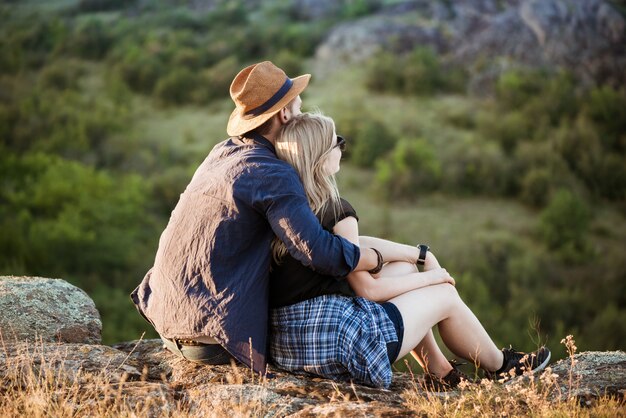 Joven hermosa pareja descansando, disfrutando de la vista en el cañón