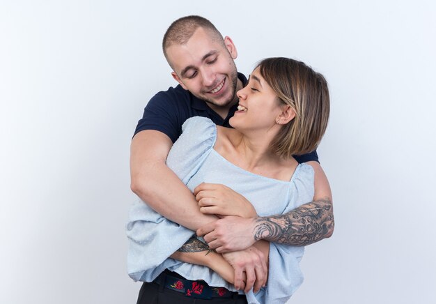 Joven hermosa pareja hombre y mujer abrazando sonriendo alegremente feliz en el amor juntos de pie