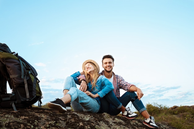 Joven hermosa pareja de viajeros disfrutando de la vista del cañón, sonriendo