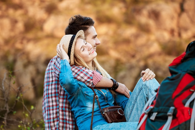 Joven hermosa pareja de viajeros disfrutando de la vista del cañón, sonriendo