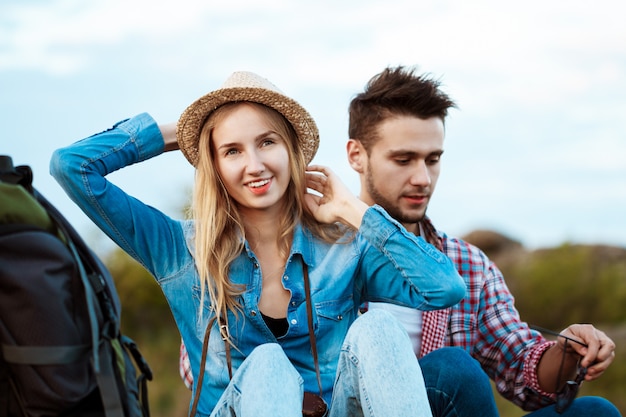 Joven hermosa pareja de viajeros disfrutando de la vista del cañón, sonriendo