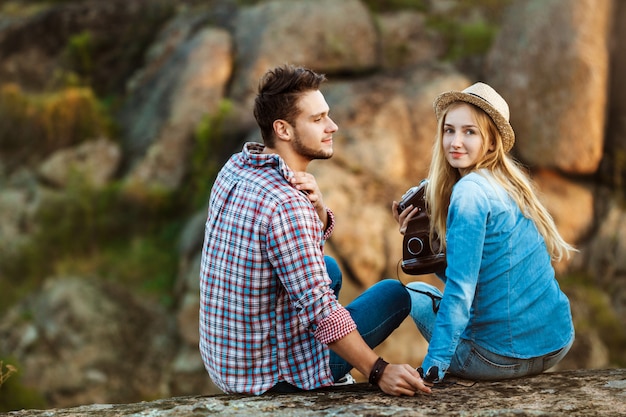 Joven hermosa pareja de viajeros disfrutando de la vista del cañón, sonriendo