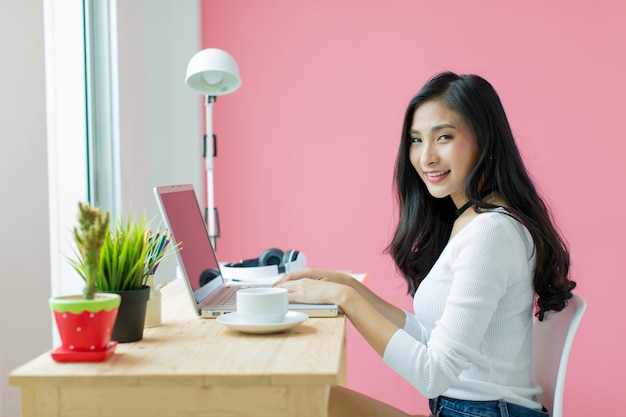 joven hermosa trabajando en el escritorio de la computadora