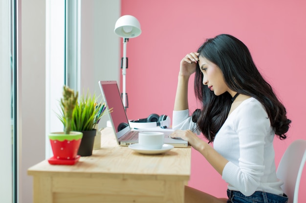 joven hermosa trabajando en el escritorio de la computadora