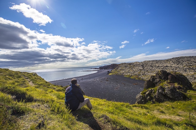 Joven en las hermosas playas de piedra de la península de Snaefellsnes en un mirador natural