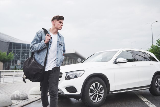 Un joven hermoso en el aeropuerto está esperando el vuelo.