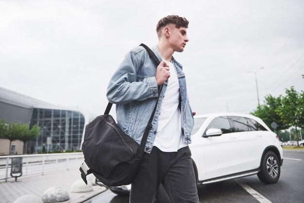 Un joven hermoso en el aeropuerto está esperando el vuelo.