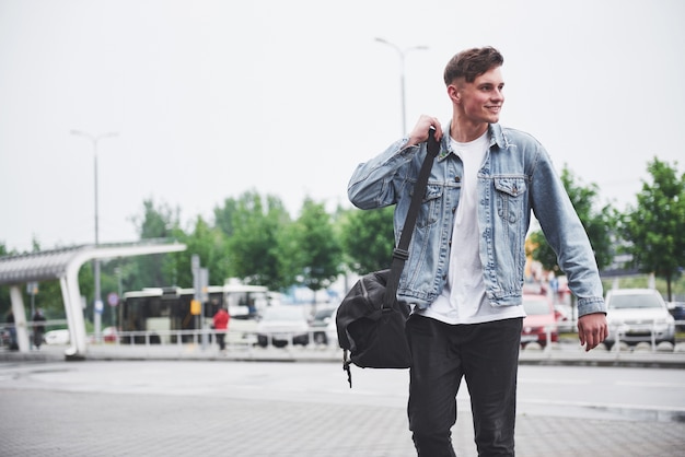 Un joven hermoso en el aeropuerto está esperando el vuelo.