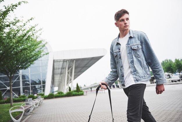 Un joven hermoso en el aeropuerto está esperando el vuelo.