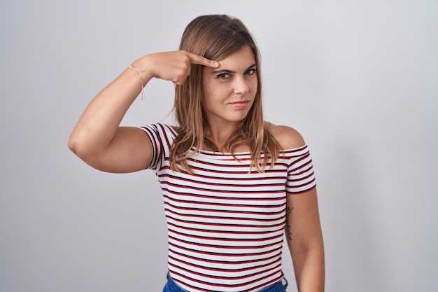 Foto gratuita joven hispana de pie sobre un fondo aislado que señala infeliz a la espinilla en la frente fea infección de acné de espinillas y problemas de piel