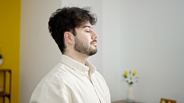 Joven hispano respirando con los ojos cerrados en casa