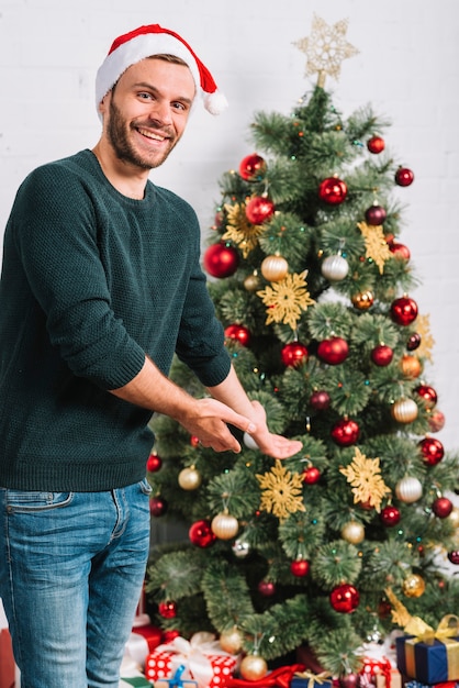 Joven, hombre, actuación, árbol de navidad