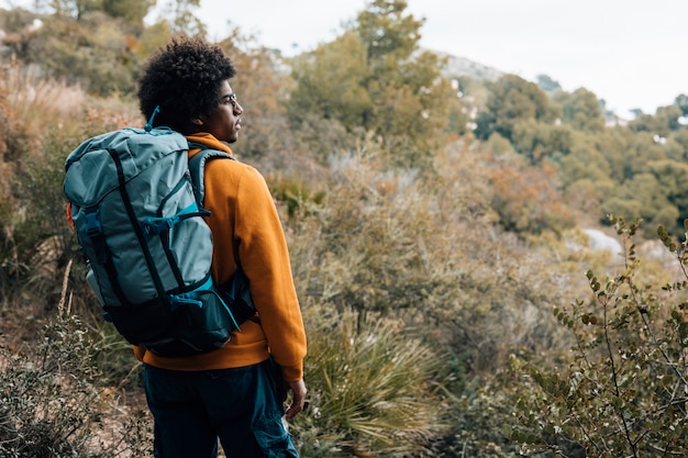 Un joven hombre africano excursionista senderismo con mochila