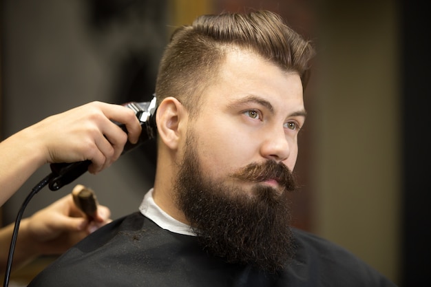 Joven hombre barbudo en el salón de peluquería