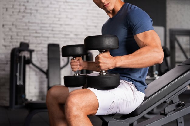 Joven hombre en forma entrenando para culturismo