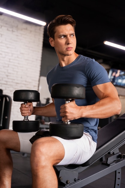 Joven hombre en forma entrenando para culturismo