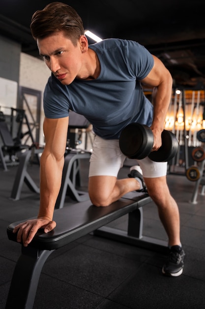 Foto gratuita joven hombre en forma entrenando para culturismo