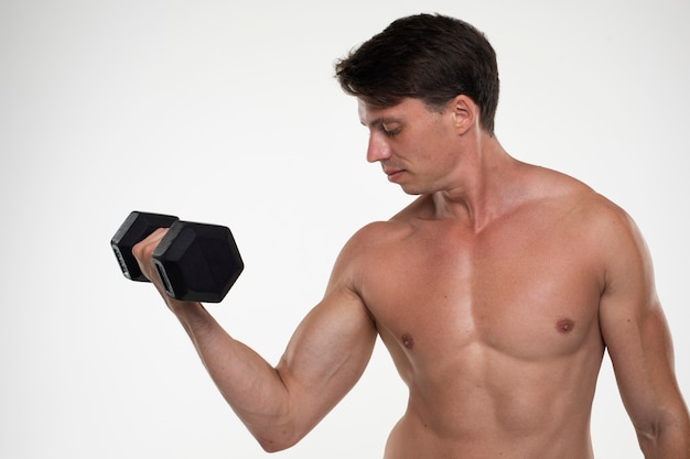 Joven hombre en forma entrenando para culturismo