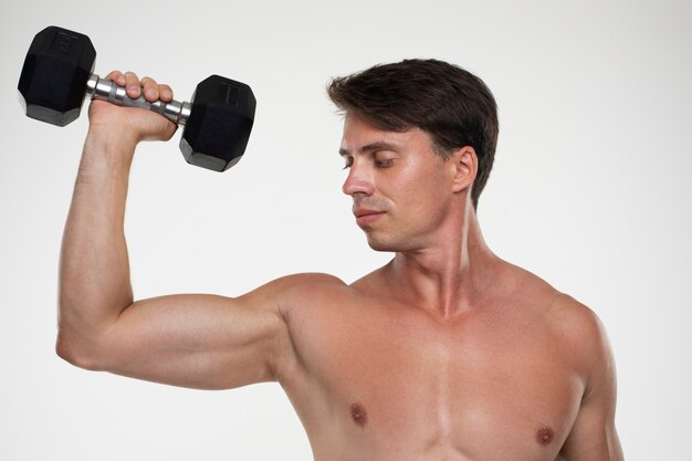 Joven hombre en forma entrenando para culturismo