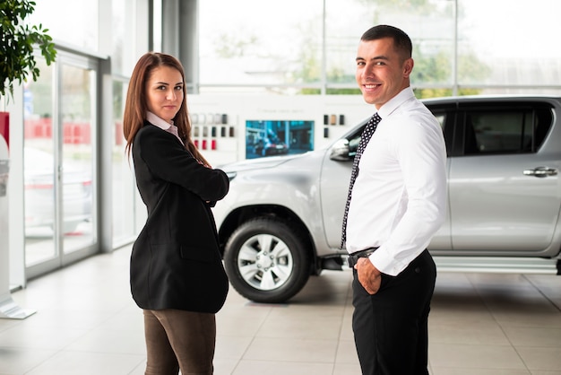 Foto gratuita joven hombre y mujer en concesionario