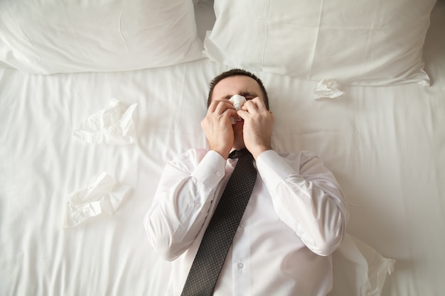 Foto gratuita joven hombre de negocios enfermo en la cama