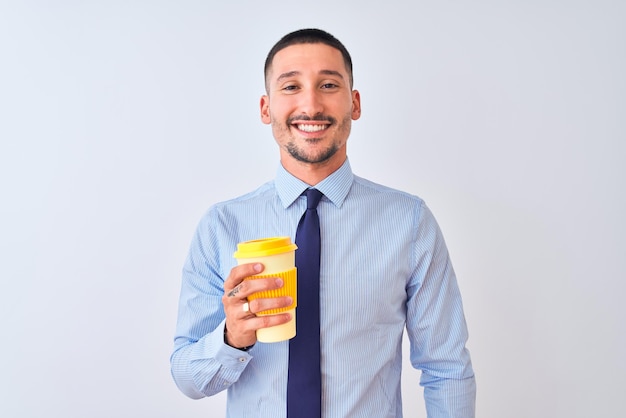 Joven hombre de negocios sosteniendo café para llevar sobre un fondo aislado con una cara feliz de pie y sonriendo con una sonrisa segura mostrando los dientes