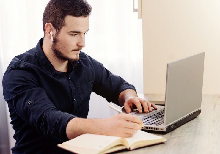 Foto gratuito joven hombre de negocios trabajando con computadora remotamente